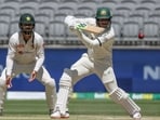 Usman Khawaja (R) plays a shot as Pakistan's Agha Salman looks on on day four of the first Test cricket match between Australia and Pakistan in Perth Usman Khawaja (R) plays a shot as Pakistan's Agha Salman looks on on day four of the first Test cricket match between Australia and Pakistan in Perth