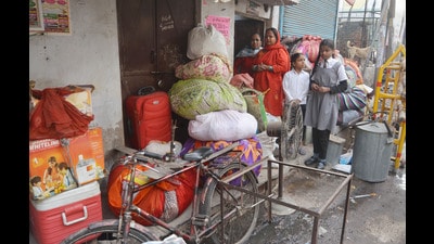 People of Akbarnagar carrying household belongings after the Lucknow Development Authority bulldozers reached the area to raze illegal structures on Thursday. (Deepak Gupta/HT)