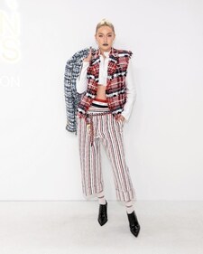 Gigi Hadid in a white button-down shirt, layered with a red, white and navy blue plaid vest over it Gigi Hadid in a white button-down shirt, layered with a red, white and navy blue plaid vest over it