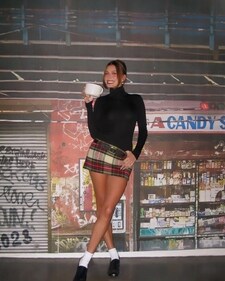 Hailey Bieber in a red, white and green checkered skirt paired with a black turtleneck top Hailey Bieber in a red, white and green checkered skirt paired with a black turtleneck top