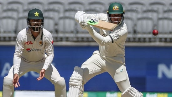 Usman Khawaja (R) plays a shot as Pakistan's Agha Salman looks on on day four of the first Test cricket match between Australia and Pakistan in Perth (AFP)