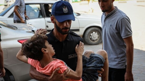 A medic carries an injured Palestinian child into the Al-Aqsa Martyrs Hospital following Israeli airstrikes in Deir Al-Balah, central Gaza, on Wednesday, Oct. 25, 2023 (Photographer: Ahmad Salem/Bloomberg) (Bloomberg)