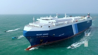 The Galaxy Leader cargo ship is escorted by Houthi boats in the Red Sea (via REUTERS)