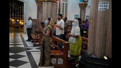 Devotees, some wearing face masks as a precaution, pray at a church ahead of Christmas in Bengaluru. (AP) Devotees, some wearing face masks as a precaution, pray at a church ahead of Christmas in Bengaluru. (AP)