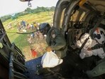 Thoothukudi: Indian Navy personnel throw relief material off a helicopter in a flood-hit area of Tamil Nadu, on Thursday. Thoothukudi: Indian Navy personnel throw relief material off a helicopter in a flood-hit area of Tamil Nadu, on Thursday.