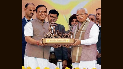 Haryana chief minister Manohar Lal Khattar presenting a momento to Assam CM Himanta Biswa Sarma during the “Vishwa Gita Paath” programme in Kurukshetra. (HT)