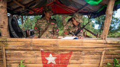 This photo taken on December 9, 2023 shows female members of the Mandalay People�s Defense Forces (MDY-PDF) standing guard at their base camp in the forest near Namhsan Township in Myanmar's northern Shan State. In the hills of northern Myanmar young women fly combat drones, treat wounded comrades and patrol the frontlines, new roles in the battle to overthrow the military junta. (Photo by AFP) / To go with 'MYANMAR-COUP-CONFLICT-WOMEN,FOCUS' (AFP)
