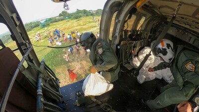 Thoothukudi: Indian Navy personnel throw relief material off a helicopter in a flood-hit area of Tamil Nadu, on Thursday. (PTI) Thoothukudi: Indian Navy personnel throw relief material off a helicopter in a flood-hit area of Tamil Nadu, on Thursday. (PTI)