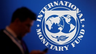 A man walks past the IMF banner. (REUTERS)