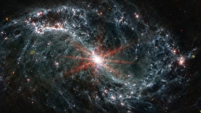 Intricate networks of gas and dust featured in the web-like spiral galaxy NGC 7496 are seen in a composite image taken by the James Webb Telescope and released by NASA on February 16, 2023. Eight red diffraction spikes extend out from its extremely bright core. Colorful dots in the background represent background galaxies.&nbsp; (NASA/ESA via REUTERS)