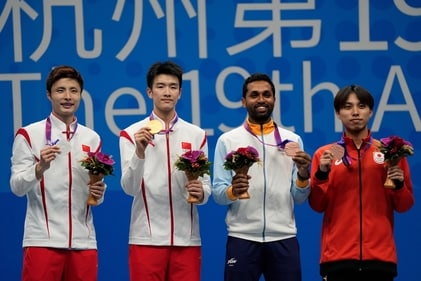 From left, silver medalist China's Shi Yuqi, gold medalist China's Li Shifeng, bronze medalists India's HS Prannoy and Japan's Kodai Naraoka celebrate on the podium during the victory ceremony for the men's singles badminton at the 19th Asian Games in Hangzhou, China (AP)