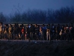 Migrants gather near the border in Eagle Pass after crossing the Rio Bravo river with the intention of turning themselves in to the U.S. Border Patrol agents to request asylum, as seen from Piedras Negras, Coahuila, Mexico December 23, 2023. REUTERS/Jose Luis Gonzalez