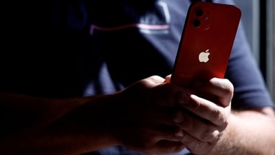 A man poses with an Apple iPhone 12 in a mobile phone store in Nantes, France. (File Photo/REUTERS)