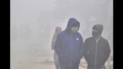 Commuter make their way along a road amid foggy condition in Amritsar.