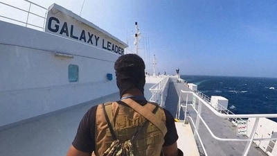A Houthi fighter stands on the Galaxy Leader cargo ship in the Red Sea (via REUTERS)