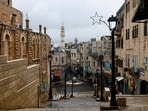 People walk along the streets of Bethlehem on Christmas Eve, in the Old City of Bethlehem