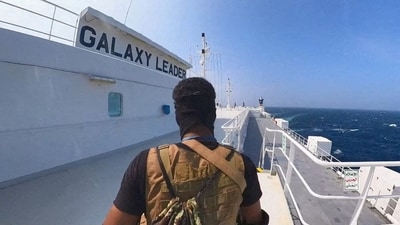 A Houthi fighter stands on the Galaxy Leader cargo ship in the Red Sea (via REUTERS)