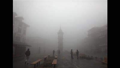 People walk through a cold and foggy morning in Srinagar on Monday. Dense fog engulfed most parts of Valley on Monday morning as there is no letup in cold conditions across the Kashmir Valley. (Waseem Andrabi /HT)