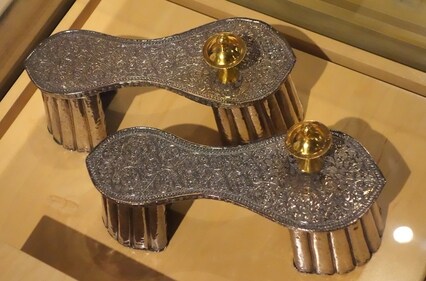 An unusually high silver-coloured paduka from 18th century Jaipur, was likely worn by a woman for an important aristocratic occasion. The fine quality of intricate engraving, the gold toe-knobs, and high stilts identified them with the upper class. (WikiCommons) An unusually high silver-coloured paduka from 18th century Jaipur, was likely worn by a woman for an important aristocratic occasion. The fine quality of intricate engraving, the gold toe-knobs, and high stilts identified them with the upper class. (WikiCommons)