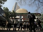 People look at a screen displaying the Sensex results on the facade of the Bombay Stock Exchange (BSE) building in Mumbai.
