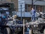 Iraqi security personnel talk to each other while positioned above armoured vehicles stationed along a street in Baghdad. Iraqi security personnel talk to each other while positioned above armoured vehicles stationed along a street in Baghdad.