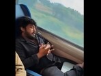 Passenger travelling on Vande Bharat train with his foot on snacks tray. Passenger travelling on Vande Bharat train with his foot on snacks tray.