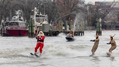 Performers dressed as Santa Claus and reindeers water-ski past crowds during the annual Christmas Eve performance by the "Waterskiing Santa" along the Old Town Alexandria Waterfront, from Founders Park to Point Lumley Park in Alexandria, Virginia, U.S., December 24, 2023. REUTERS/Amanda Andrade-Rhoades (REUTERS)
