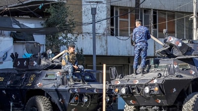 Iraqi security personnel talk to each other while positioned above armoured vehicles stationed along a street in Baghdad. (AFP) Iraqi security personnel talk to each other while positioned above armoured vehicles stationed along a street in Baghdad. (AFP)