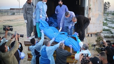 Medics unload the bodies of Palestinians killed in the north of the Gaza Strip and turned over by the Israeli military during a mass funeral in Rafah. (AP) Medics unload the bodies of Palestinians killed in the north of the Gaza Strip and turned over by the Israeli military during a mass funeral in Rafah. (AP)