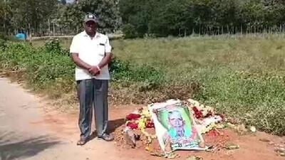 Man stands beside his fathers grave on the roadside in Tumkur taluk on Monday. (HT photo) Man stands beside his fathers grave on the roadside in Tumkur taluk on Monday. (HT photo)