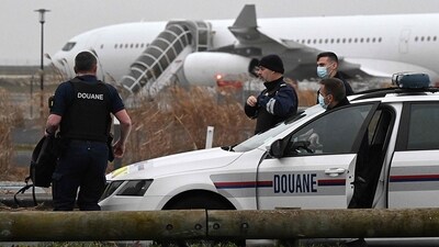 French customs officers stand next to a customs car with an Airbus A340 in the background which was grounded on the tarmac since December 21 over suspected "human trafficking", at the Vatry airport. (AFP) French customs officers stand next to a customs car with an Airbus A340 in the background which was grounded on the tarmac since December 21 over suspected "human trafficking", at the Vatry airport. (AFP)
