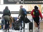 People walk through Reagan Washington National Airport in Arlington. (AP Photo/Susan Walsh)
