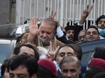 Pakistan's former Prime Minister Nawaz Sharif, center in brown coat, waves to his supporters as he leaves after a court hearing in Islamabad, Pakistan, Tuesday, Dec. 12, 2023.