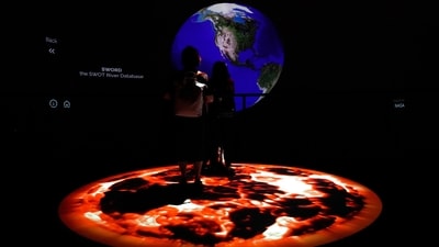 People look at artwork by Yiyun Kang at the COP28 U.N. Climate Summit, Sunday, in Dubai, United Arab Emirates. (AP)
