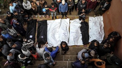 People stand over the shrouded bodies of loved ones killed during Israeli bombardment at Nasser Hospital in Khan Yunis on the southern Gaza Strip (AFP) People stand over the shrouded bodies of loved ones killed during Israeli bombardment at Nasser Hospital in Khan Yunis on the southern Gaza Strip (AFP)