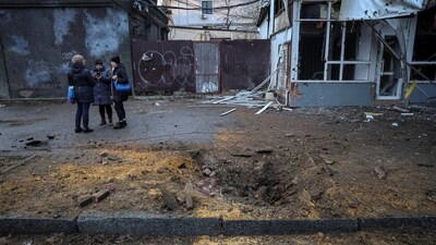 Local residents stand at a site of a yesterday's Russian military strike, amid Russia's attack on Ukraine, in Kherson. (REUTERS)