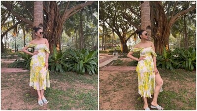 Another look from Rakul's holiday diaries shows the actor in a floral-printed midi dress. It features yellow flowers and green leaf patterns, a pleated tulle skirt, a tiered silhouette, a square neckline, a thigh-high slit, and a cinched waist. (Instagram) Another look from Rakul's holiday diaries shows the actor in a floral-printed midi dress. It features yellow flowers and green leaf patterns, a pleated tulle skirt, a tiered silhouette, a square neckline, a thigh-high slit, and a cinched waist. (Instagram)
