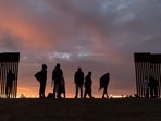 Parents-to-be from Haiti stand at a gap in the US-Mexico border wall after having travelled from South America to the United States, in Yuma, Arizona, Parents-to-be from Haiti stand at a gap in the US-Mexico border wall after having travelled from South America to the United States, in Yuma, Arizona,
