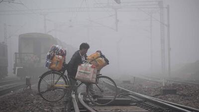A man with his cycle crosses the railway tracks amid dense fog, in Prayagraj, on Thursday. (ANI) A man with his cycle crosses the railway tracks amid dense fog, in Prayagraj, on Thursday. (ANI)
