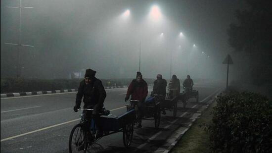 Vegetable vendors riding their cycle rickshaws to the wholesale market in Chandigarh on a foggy Thursday morning. (AFP Photo)