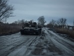 A Ukrainian serviceman rides in an armoured vehicle along a road near a front line, amid Russia's attack on Ukraine, in the Kharkiv region,