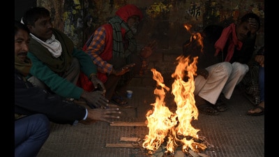 '' People getting relaxed from shivering cold by sittingnear bonfire '', at Lucknow, Uttar Pradesh. [ Photo by Dheeraj Dhawan / Hindustan Times ] (HT File Photo)
