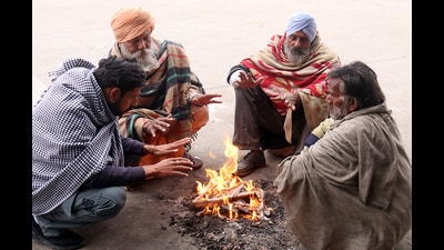 People huddle around a bonfire to warm themselves amid cold weather in grain market, Bathinda, on Saturday. (Sanjeev Kumar/HT) People huddle around a bonfire to warm themselves amid cold weather in grain market, Bathinda, on Saturday. (Sanjeev Kumar/HT)