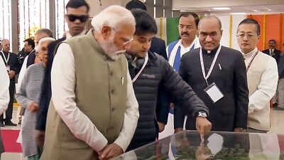 Prime Minister Modi with Union civil aviation minister Jyotiraditya Scindia and others after the inauguration of Maharshi Valmiki International Airport, in Ayodhya. Modi is being briefed by Scindia about the details of the newly inaugurated airport. (PTI)