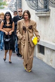 Tiffany Hsu wears beige pants, cut put coat, yellow bag outside Prada during the Milan Fashion Week. (hoto by Christian Vierig/Getty Images)