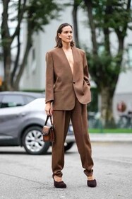 Chiara Baschetti wears a brown oversized blazer jacket, matching pants, a leather bag, outside Tod’s, during the Milan Fashion Week. (Photo by Edward Berthelot/Getty Images)