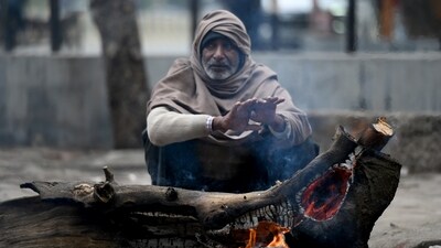 A man around a bonfire to protect themselves from winter on a cold morning. (Hindustan Times) A man around a bonfire to protect themselves from winter on a cold morning. (Hindustan Times)