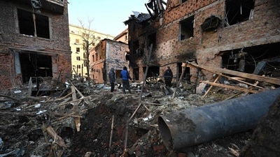 Local residents inspect damages outside an apartment building after the overnight Russian drones attack in Kharkiv, December 31, 2023. (AFP) Local residents inspect damages outside an apartment building after the overnight Russian drones attack in Kharkiv, December 31, 2023. (AFP)