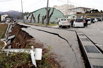 People stand next to large cracks in the pavement after evacuating into a street in the city of Wajima, Ishikawa prefecture on January 1, 2024, after a major 7.5 magnitude earthquake struck the Noto region in Ishikawa prefecture. (AFP) People stand next to large cracks in the pavement after evacuating into a street in the city of Wajima, Ishikawa prefecture on January 1, 2024, after a major 7.5 magnitude earthquake struck the Noto region in Ishikawa prefecture. (AFP)