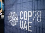 A man walks past a COP28 sign at the venue of the United Nations climate summit in Dubai on November 30, 2023. The UN climate conference opens in Dubai on November 30 with nations under pressure to increase the urgency of action on global warming and wean off fossil fuels, amid intense scrutiny of oil-rich hosts UAE. (AFP)